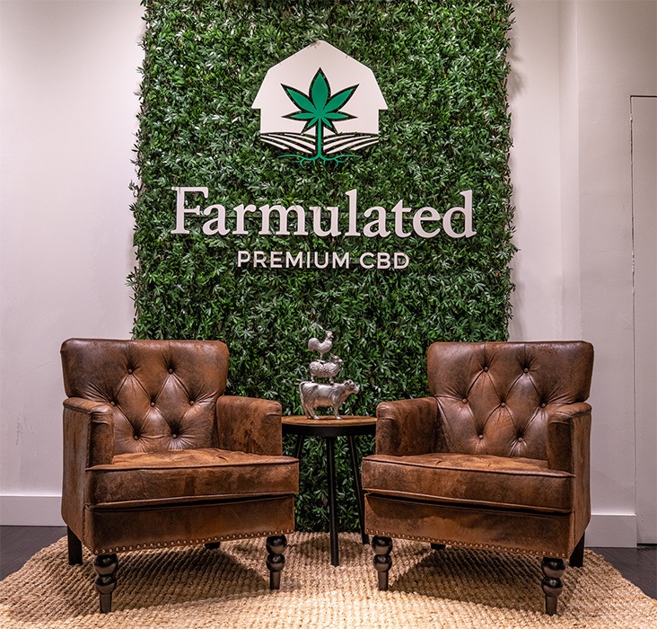 Farmulated retail interior lounge area and ivy-covered feature wall with large logo sign