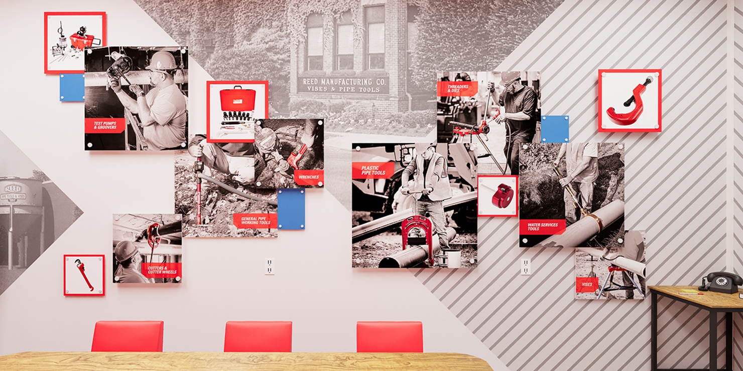 REED Manufacturing conference room feature wall with 3D collage art and red chairs at wooden table