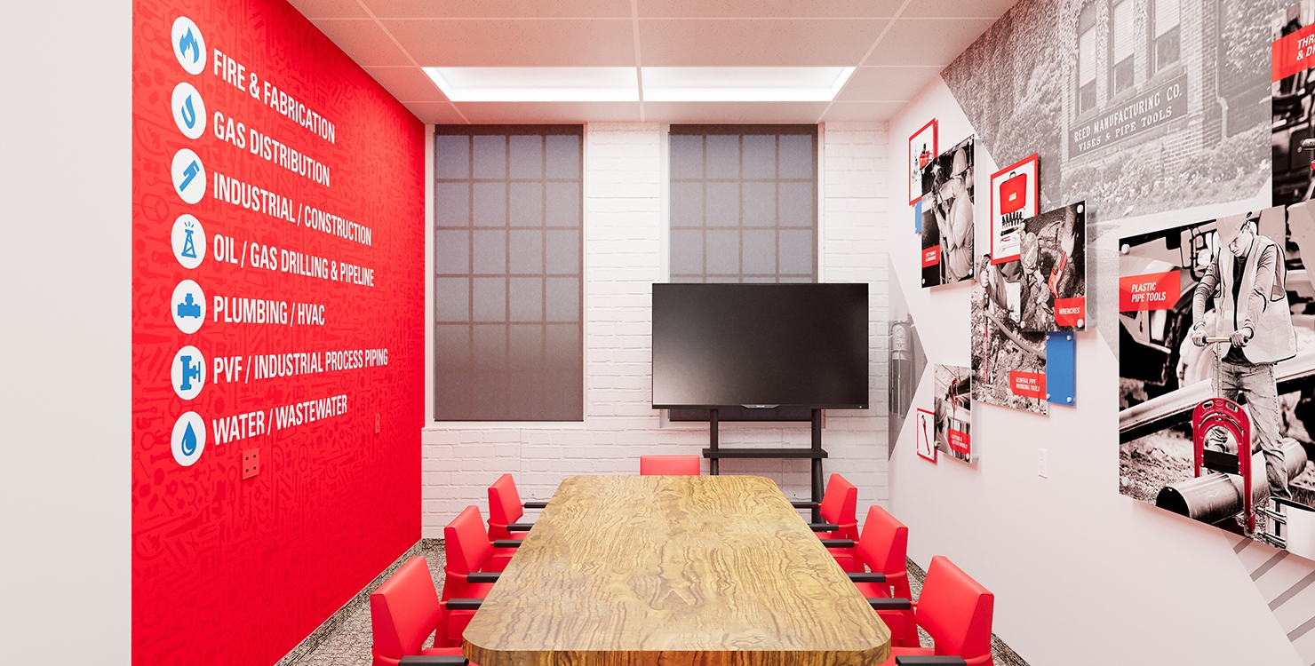 REED Manufacturing conference room with table and red chairs centered and TV on far wall