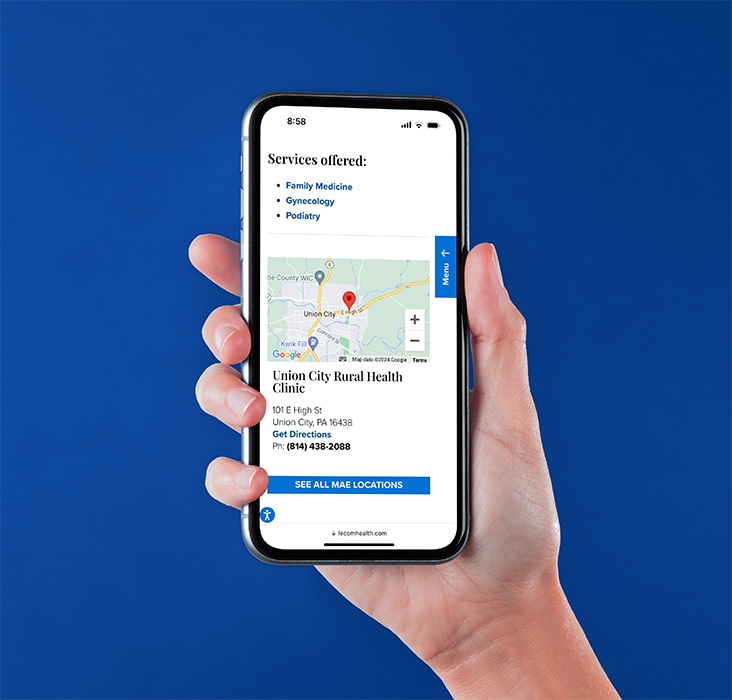 Hand holding iPhone displaying LECOM Health website map.